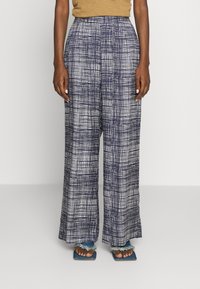 Brede benenbroek van lichtgewicht stof met een marineblauw-wit ruitpatroon. Soepele textuur, hoge taille en zijzakken.