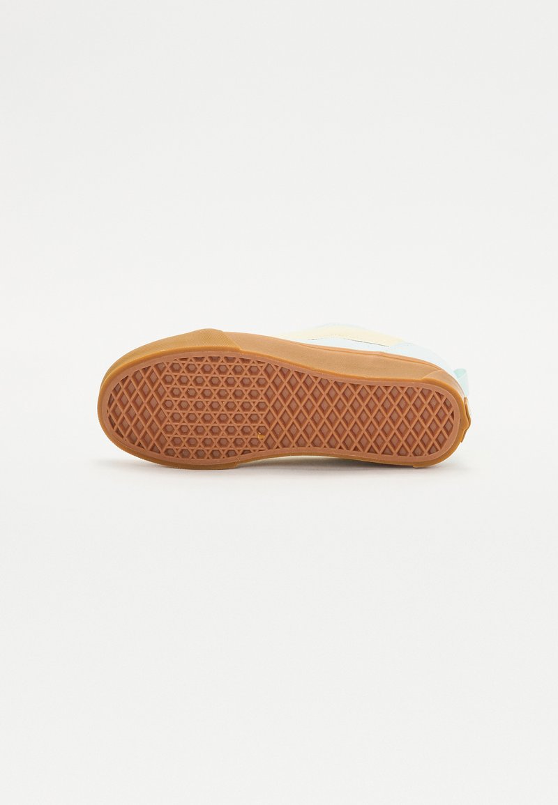 Semelle de chaussure en caoutchouc avec une texture en nid d'abeille marron, présentant un design supérieur bleu clair et jaune avec des accents contrastants.