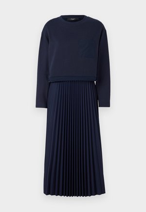 Abito blu navy con top a maniche lunghe cropped e tasca applicata sopra una gonna plissettata. Tessuto morbido e design semplice.