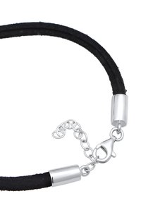 Svart mockasnudekedja med klämma och förlängningskedja i silverfärgad metall. Har släta cylindriska ändar och en säker lobsterklämma.