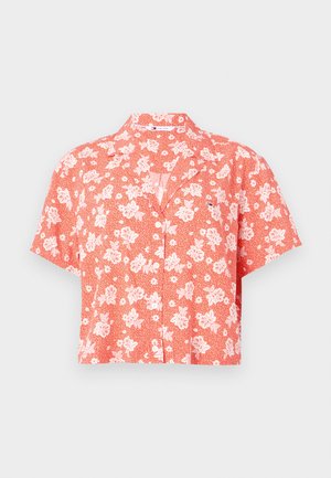 Rövid ujjú, korallszínű, fehér virágmintás és apró pöttyös ing, galléros nyakkivágással és kényelmes szabással.