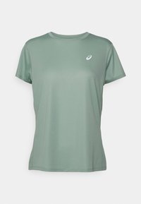 Sportovní tričko s krátkým rukávem ze světle zelené látky, s kulatým výstřihem a malým bílým logem na levé horní části hrudi.
