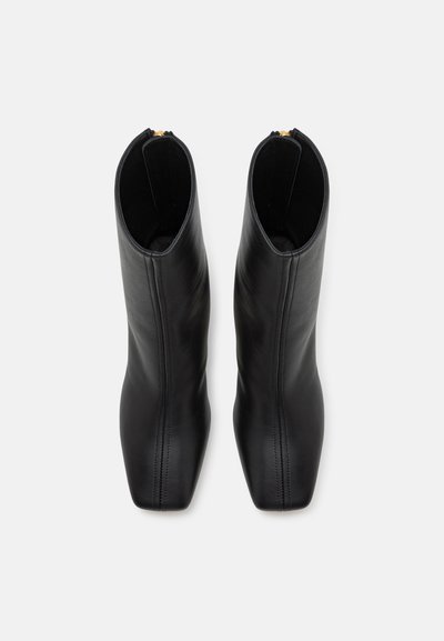 Stivaletti neri in pelle con punta quadrata, caratterizzati da una superficie liscia e da una cerniera dorata nella parte superiore per la chiusura.