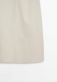 Beige, knælange nederdel lavet af glat stof med lige snit, der har en midterste søm og minimal detaljering.