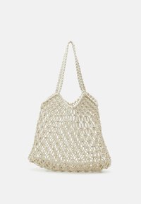 Tkaná taška z přírodních vláken, v světle béžové barvě, s otevřeným háčkovaným designem a dvěma smyčkovými uchy pro nošení.