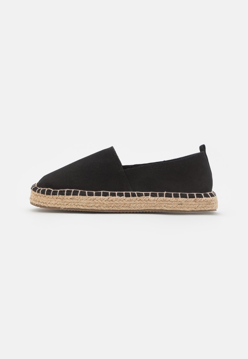 Black canvas espadrille with a rounded toe, jute sole, and a woven trim. Features a slip-on design and soft texture.