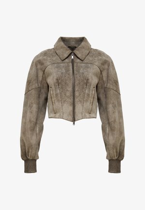 Lühendatud seemisnahast jakk summutas pruunis toonis, millel on krae, lukk ja soonilised mansetid tekstuuri ja struktuuri lisamiseks.