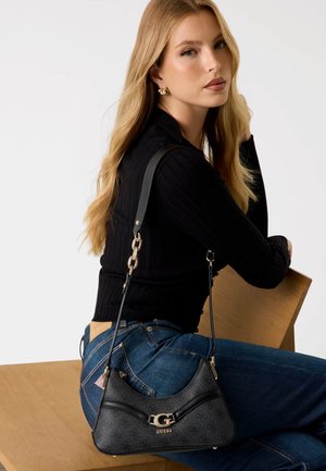 Sac à épaule en cuir noir avec une forme incurvée, quincaillerie dorée et un logo à l'avant. Doté d'une sangle fine et ajustable.