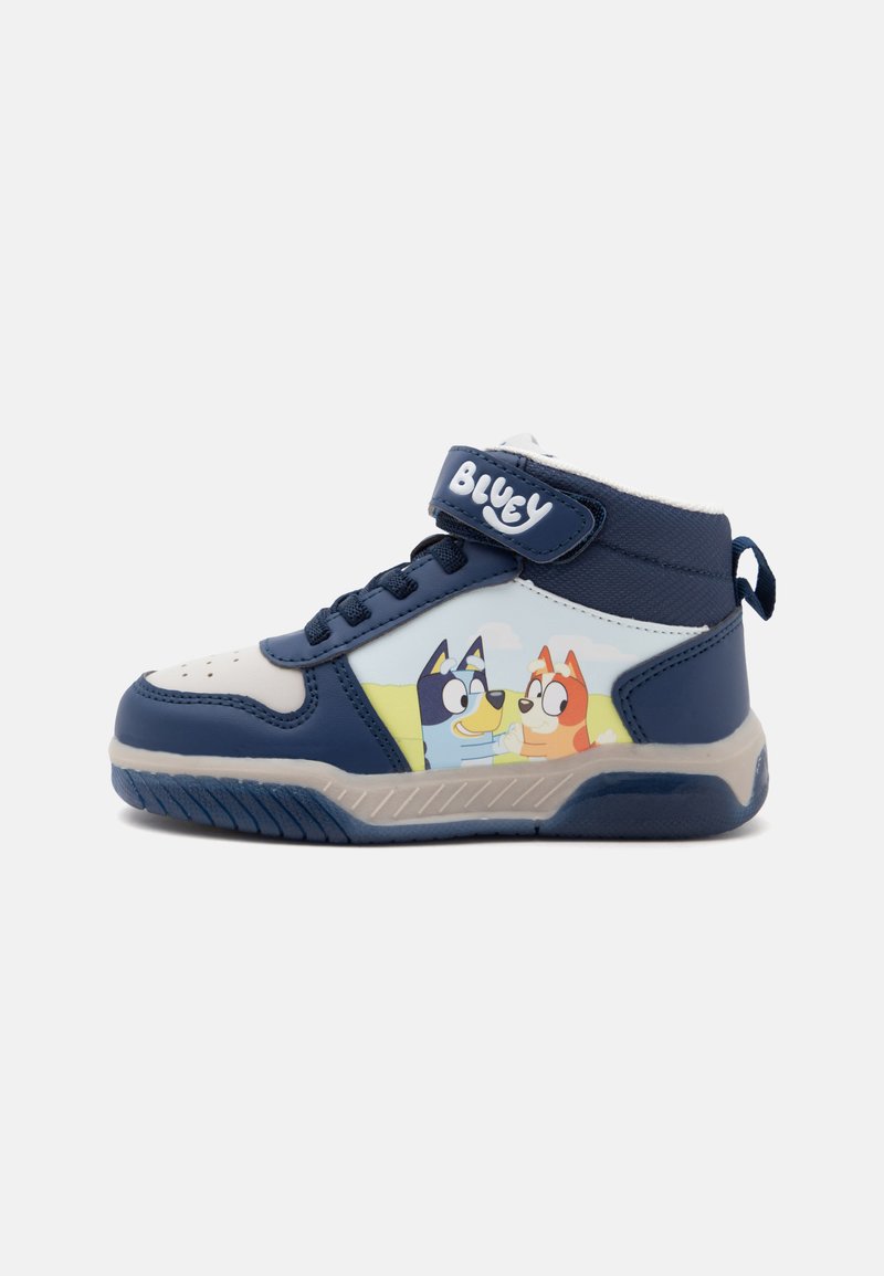 Baskets enfant bleu marine et blanc avec des personnages de chiens de dessin animé sur le côté et une bride velcro étiquetée "Bluey."