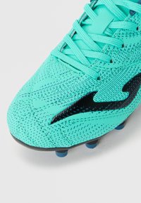 Scarpini da calcio color turchese chiaro con una parte superiore testurizzata, accento del logo nero, design con lacci e sei tacchetti blu sulla suola per la trazione.