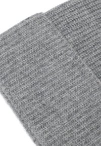 Grijze gebreide wolstof met een ribbelstructuur, met subtiele schaduwvariaties en een zachte, fuzzy uitstraling.