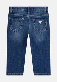 Shorts in denim blu scuro dal texture liscia, con una vita, due tasche posteriori e un piccolo etichetta con logo vicino alla tasca destra.
