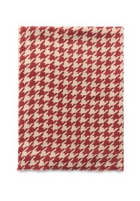Czerwono-kremowy materiał w wzór houndstooth z frędzlami na brzegach. Miękka tekstura, prostokątny kształt, z naprzemiennymi blokami kolorów i ostrymi kątami.