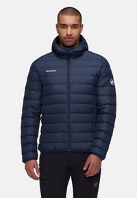 Chaqueta acolchada navy con cremallera en el frente, diseño de costura horizontal, capucha ajustable y logotipo en el pecho y la manga.