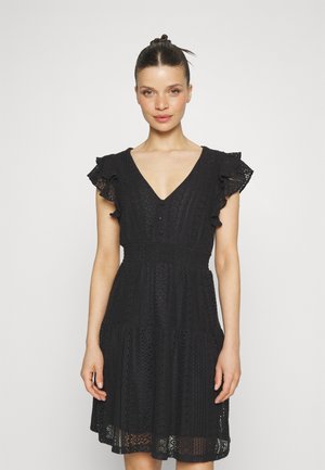 Black lace dress featuring a V-neck, short ruffled sleeves, a fitted waist, and a tiered skirt with embroidered patterns.