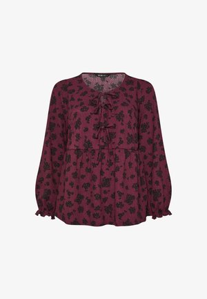 Bordeaux lange mouwen blouse van lichte stof, met een zwart bloemenpatroon, strik vooraan en gerimpelde manchetten. De onderrand is recht afgeknipt.