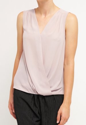 Sleeveless pale mauve V-neck blouse with draped front, worn with black textured pants, shown from neck to hips.