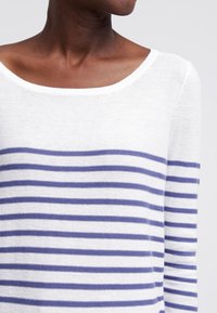 Biały sweter z poziomymi granatowymi paskami, z szerokim, okrągłym dekoltem i długimi rękawami. Miękka tekstura, lekki materiał.