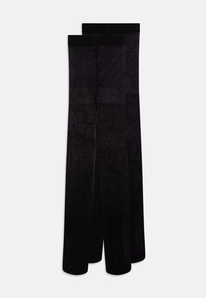 Sorte, uigennomsiktige strømpebukser laget av et mykt, elastisk materiale med en glatt tekstur. Har bredt liv for komfort og støtte.