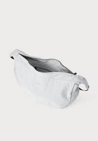Helle graue Tasche aus weichem, strukturiertem Stoff, mit Reißverschluss oben und minimalistischer Gestaltung. Verfügt über einen Seitenriemen für einfachen Transport.