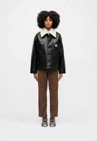 Czarna skórzana kurtka z kremowym kołnierzem z futerka ekologicznego, z dwoma przednimi kieszeniami, zapięciem na guziki oraz małą naszywką z logo na lewej piersi.