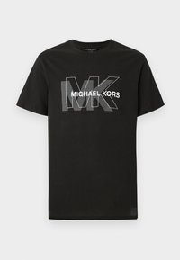 Čierne tričko s krátkymi rukávmi s prekrývajúcimi sa šedými písmenami "MK" a textom "MICHAEL KORS" v bielej farbe naprieč hrudníkom.