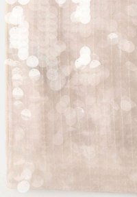 Tissu transparent de couleur beige clair, featuring des sequins ronds et réfléchissants disposés dans un motif dispersé sur un fond en maille.