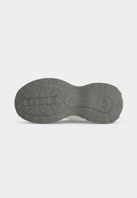 Semelle d'une chaussure grise avec un profond cramponnage comportant des motifs d’étoiles et le nom de la marque Onitsuka embossé près du talon.