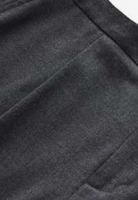 Black fabric with a smooth texture, featuring subtle stitching details and a clean finish. The material appears soft and structured.