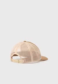 Μπεζ δικτυωτό καπέλο τύπου τράκερ με ρυθμιζόμενο λουράκι snapback, εμφανιζόμενο σε απλό ανοιχτό φόντο.