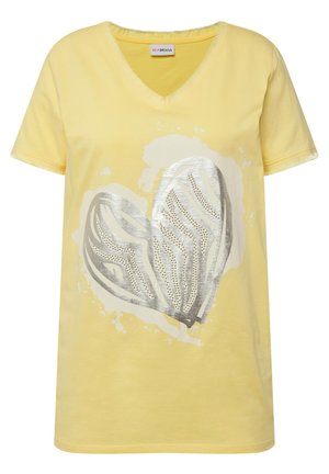 Żółta bawełniana koszulka z dekoltem w serek, z dużym srebrnym sercem w wzorach perforowanych oraz tłem w stylu akwareli.