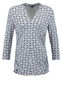 Långärmad topp i ljusblått med ett svart geometriskt mönster. Har en V-ringning och sidofållning för en skräddarsydd passform.