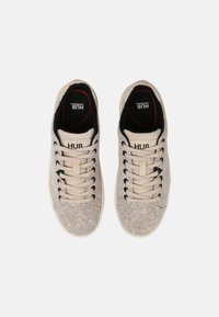 Baskets beiges à texture tachetée, dessus en textile, design à lacets, doublure intérieure noire, et marque "HUB" sur la languette.