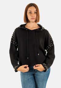 Sudadera negra con cordón, decorada con tachuelas plateadas en los hombros y puños, corte holgado, tejido suave, longitud corta.