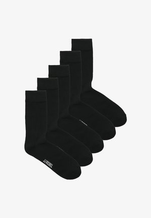 Cinco pares de calcetines negros lisos de longitud media, dispuestos en una fila escalonada, con el texto "JJ REBEL" visible en la zona de los dedos.