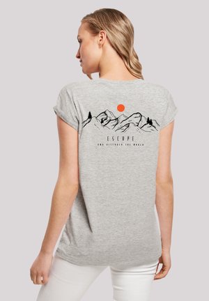 Gray cotton t-shirt features a back graphic of mountains, trees, and a sun. Short sleeves and relaxed fit. Text reads "ESCAPE AND DISCOVER THE WORLD."