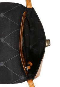 Sorte stofforet åbent tan læder håndtaske, der viser indvendig lynlås lomme og metalspænde på siden.