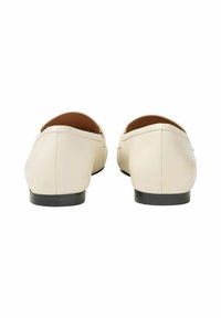 Ljust beige läderloafers med en slät yta, rund tå och en låg svart sula. Enklare sömmar som accentuerar kanterna.