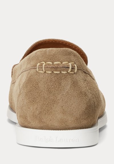 Mocassin en daim beige à semelle blanche vu de dos, présentant des coutures détaillées et un marquage embossé "Ralph Lauren" sur la semelle.