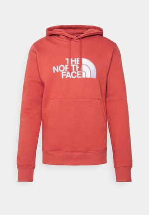 Sudadera de algodón roja con un bolsillo tipo canguro, puños acanalados y un logotipo blanco que presenta el nombre de la marca y un diseño de media luna en el pecho.