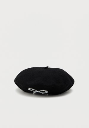 Black wool beret with a decorative bow made of small white pearls on the side, displayed on a plain white background.