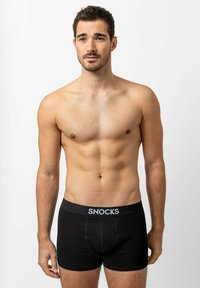Zwarte boxershorts van zacht materiaal met een aansluitende pasvorm, met een grijze tailleband waarop de tekst "SNOCKS" opvallend is weergegeven.