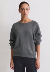 Szara bluza z okrągłym dekoltem, rękawami raglanowymi i ściągaczami przy mankietach. Posiada subtelne logo po lewej dolnej stronie. Tkanina o fakturze.