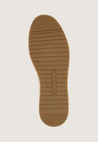 Semelle en caoutchouc avec une surface texturée. Présente des rainures horizontales et un logo central estampé sur une forme plate et arrondie. Taille marquée comme étant 40.