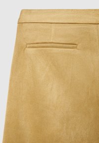 Jupe en daim jaune à la texture lisse, avec une poche arrière et une ceinture cintrée. La surface présente une finition douce et mate.