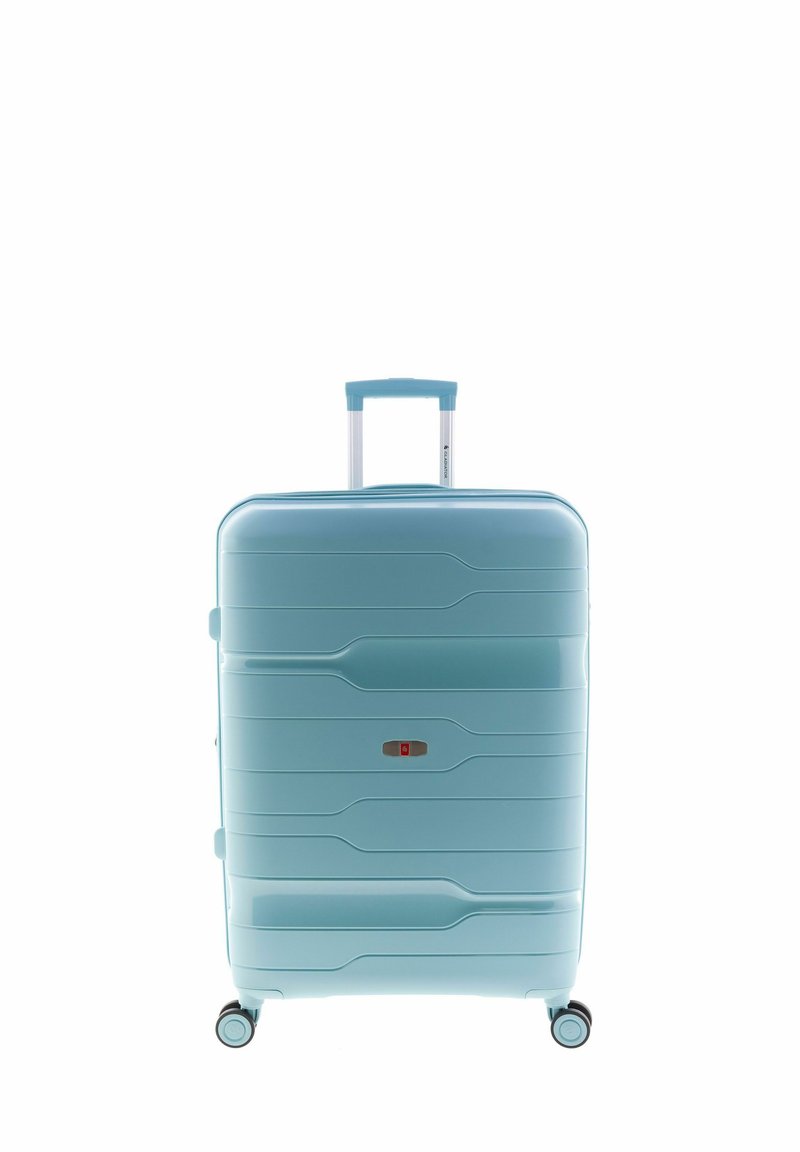 Maleta rígida en azul claro, con líneas curvas grabadas en la superficie, asa extensible, cuatro ruedas y detalle de pestillo rojo en la parte frontal.