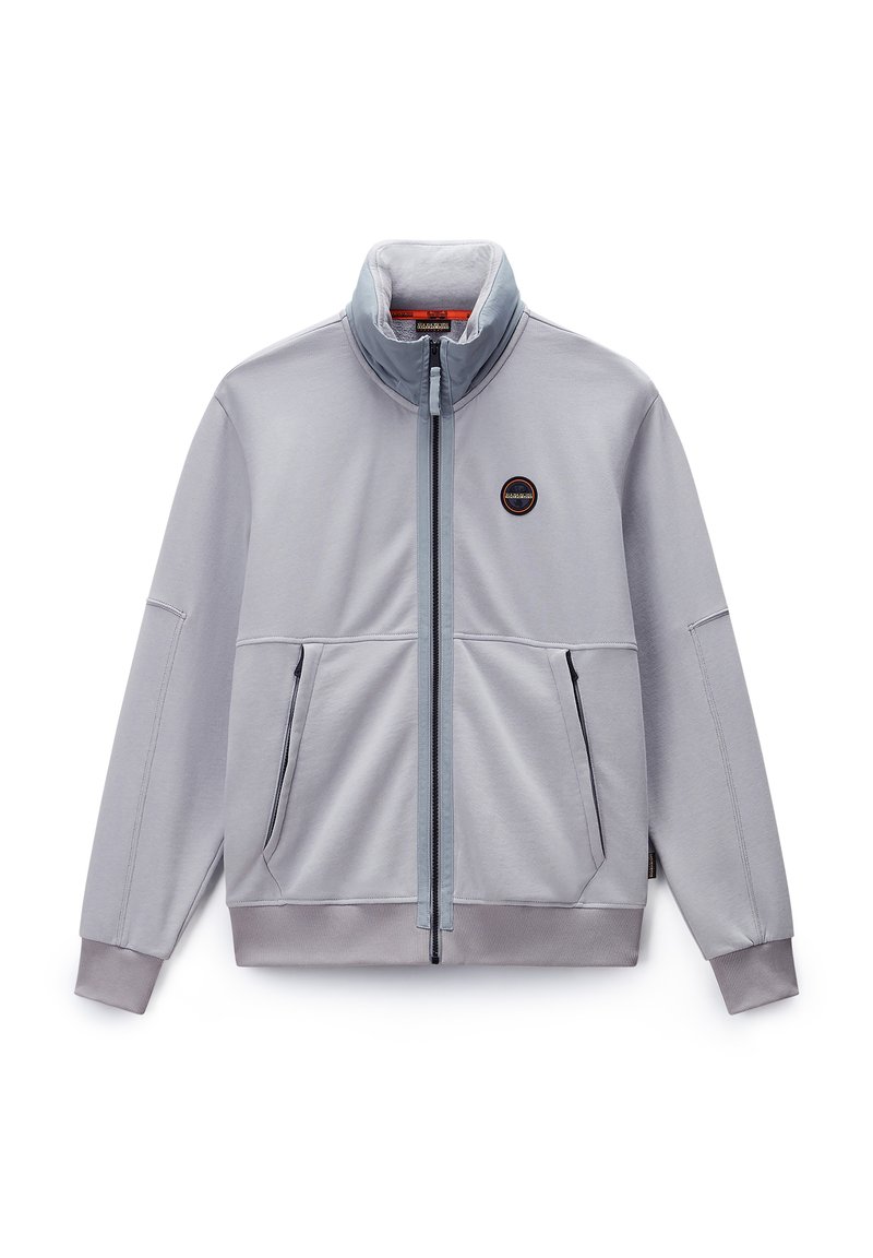 Hellgraue Zip-Jacke aus glattem Stoff, mit hohem Kragen, zwei Fronttaschen und einem runden Logo auf der linken Brust.