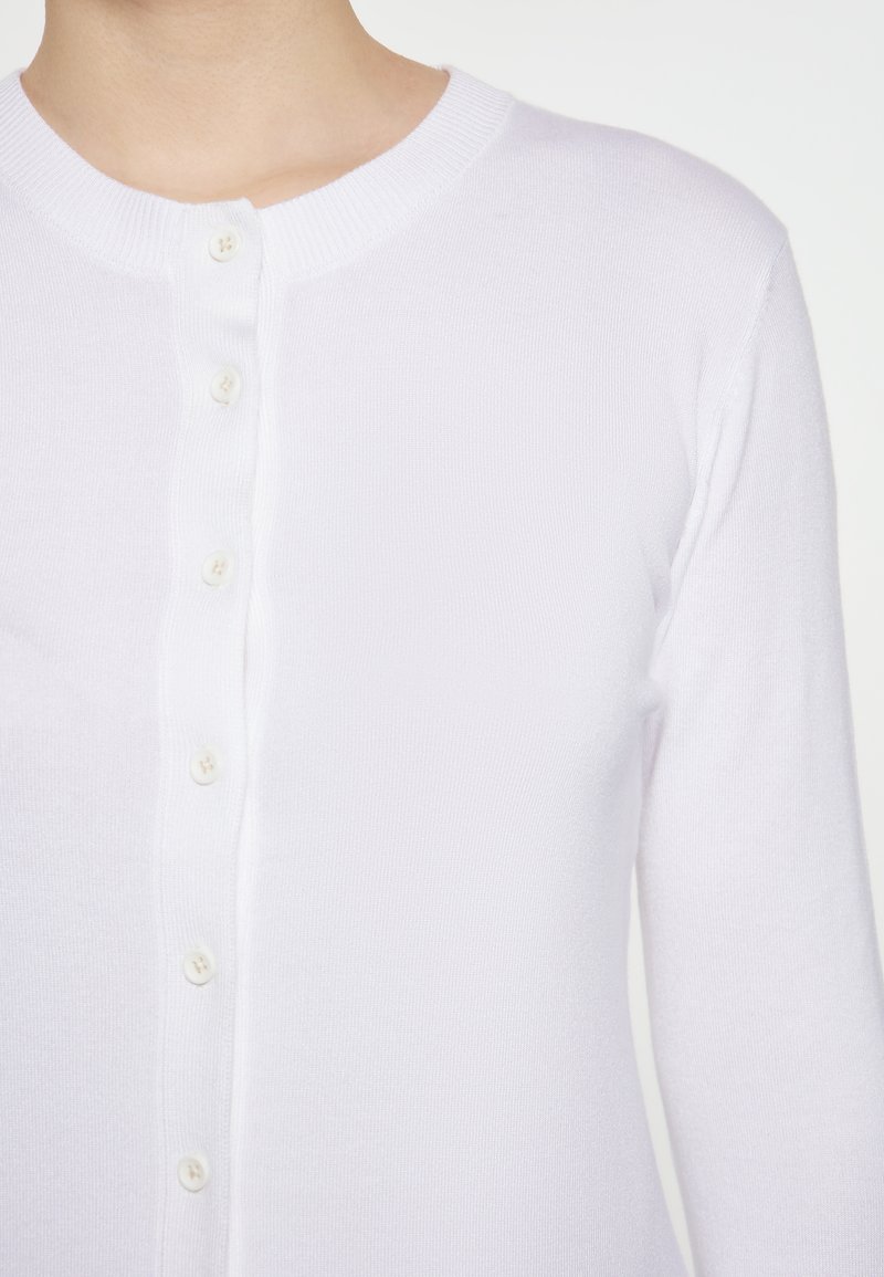 Witte gebreide cardigan met een ronde hals, lange mouwen en een sluiting met zes knopen aan de voorkant. Glad textuur, slim-fit ontwerp en geen zichtbare patronen.
