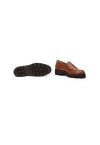 Mocasines de cuero marrón con punta redondeada, costuras decorativas, acentos de tachuelas y una suela de goma negra texturizada.