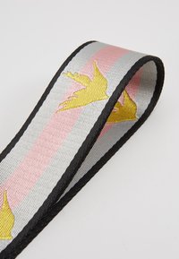 Tkaná stužka s jemně střídajícími se růžovými, stříbrnými a černými pruhy s motivy žlutých ptáků; měkká textura, šířka 3 cm.